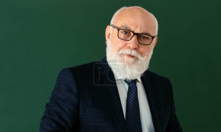 Photo for Elderly teacher. Funny professor or scientist in a elegant suit. Copy space on chalkboard, blackboard, banner - Royalty Free Image