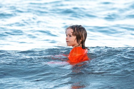 Téléchargez les photos : Enfant nageant dans la mer. Un gamin qui s'amuse sur la plage. Vacances d'été pour enfants. Station estivale - en image libre de droit