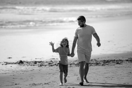 Foto de Padre e hijo caminando sobre el mar. Papá y el niño jugando al aire libre, disfrutar del día de primavera - Imagen libre de derechos