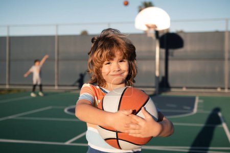 Foto de Baloncesto niños juego de entrenamiento. Niño jugando baloncesto con pelota de baloncesto. Niño posando con una pelota de baloncesto - Imagen libre de derechos