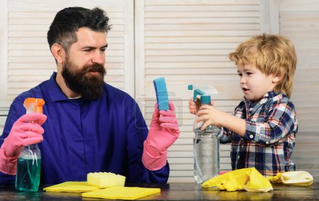 Téléchargez les photos : Père enseigne une propreté à un fils. Mignon garçon et son père faire le ménage à la maison - en image libre de droit