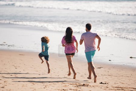 Photo for Happy family father, mother and baby son have fun together, child run by water pool along sea surf on black sand beach. Travel lifestyle, parents with kids on summer vacation - Royalty Free Image