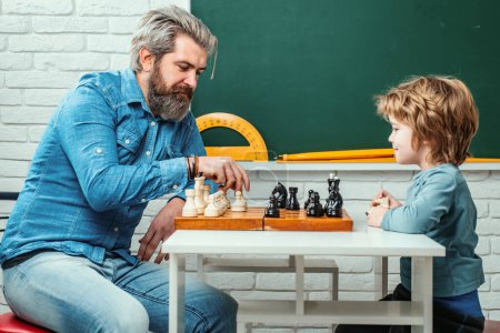Foto de Padre enseñando a su hijo a jugar al ajedrez. Estrategia de ajedrez. Éxito de ajedrez y ganar. Concepto de educación y personas. Feliz día de los padres - Imagen libre de derechos
