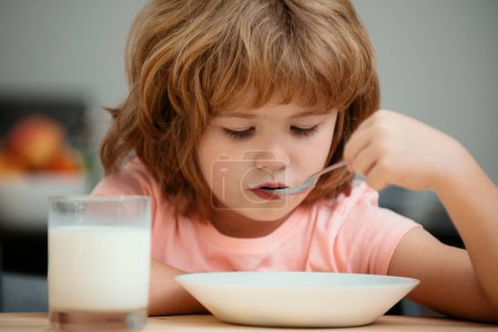 Téléchargez les photos : Blanc tout-petit enfant garçon manger soupe saine dans la cuisine - en image libre de droit