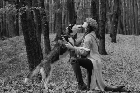 Foto de Parque de mujeres de otoño. Hermosa mujer joven jugando con perro husky divertido al aire libre en el parque. Tiempo de otoño, noviembre - Imagen libre de derechos