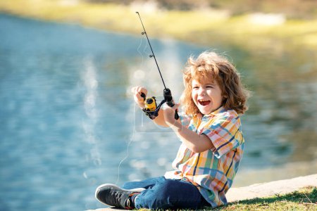 Foto de Retrato de niño emocionado pescando. Emocionado niño sorprendido sentado cerca del lago y la pesca - Imagen libre de derechos
