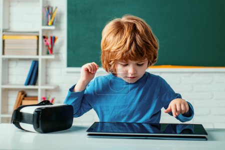 Photo for Schoolboy with digital tablet in school classroom. Pupil in class using digital tablet. Education. School for Talented pupil - Royalty Free Image