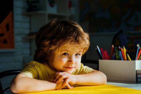 Foto de Niño lindo en el aula cerca del escritorio de pizarra. Alumnos aprendiendo letras y números. Niños aprendiendo - Imagen libre de derechos