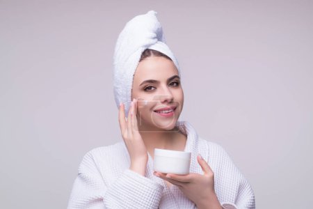 Photo for Beauty portrait of a beautiful woman applying face cream. Woman applying moisturizing skincare cream, lotion or mask for skin lifting and anti-aging effect, studio background - Royalty Free Image