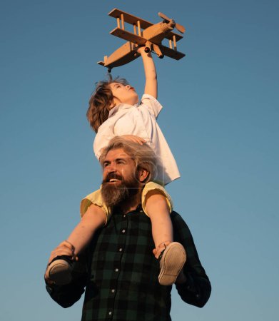 Foto de Día de los Padres. Padre e hijo. Niño con juguete avión sentado en los hombros de los padres en el cielo - Imagen libre de derechos