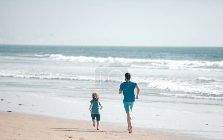 Foto de Padre e hijo corriendo en el mar. Papá y su hijo se divierten al aire libre. Viajes en familia, vacaciones, padres concepto de día - Imagen libre de derechos