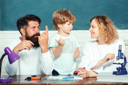Photo for Mother father and son together schooling. Boy from elementary school. Parents encouraging their little son before the first day of school. Educational process - Royalty Free Image