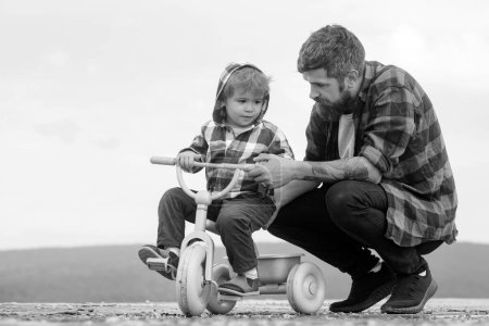 Photo for Father and son cycling with kids bike outdoor. cute Little boy learn to ride a bike with his daddy. Dad teaching son to ride bicycle - Royalty Free Image
