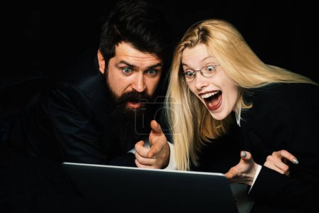 Photo for Excited couple rejoice in winning an internet lottery made bets on website. Happy couple celebrating victory in online competitions enjoying success. Portrait of a happy business couple looking at - Royalty Free Image