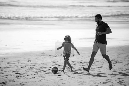 Photo for Daddy with kid boy playing on a summer day. Father and son play soccer or football on the beach. Lifestyle and family vacation, happiness men concept - Royalty Free Image