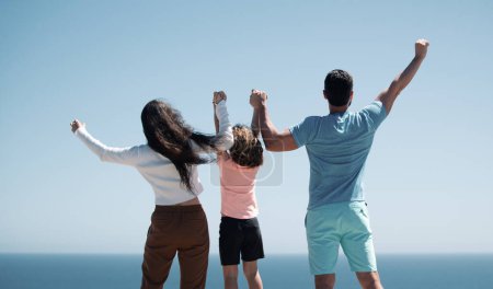 Foto de Familia de verano. Vista trasera de la feliz familia joven caminando en la playa. Niño con padres tomados de la mano. Paleta de longitud completa - Imagen libre de derechos