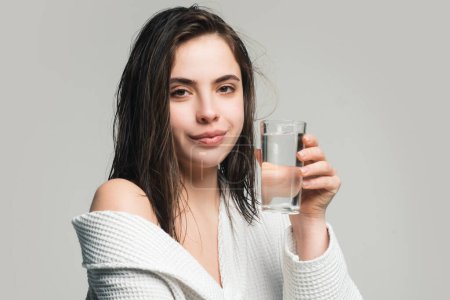 Foto de Una mujer bebiendo agua. Mujer hermosa, cuidado de la piel femenina, primer plano retrato de belleza de la cara - Imagen libre de derechos
