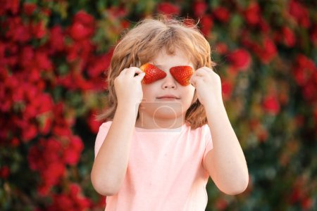 Photo for Child fun with strawberries. Little kid eating strawberry in nature. Child enjoys a delicious berry - Royalty Free Image