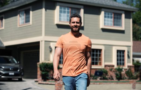 Portrait d'un homme confiant debout à l'extérieur d'une nouvelle maison. Succès agent immobilier achat de maison à des fins d'investissement. Heureux et beau