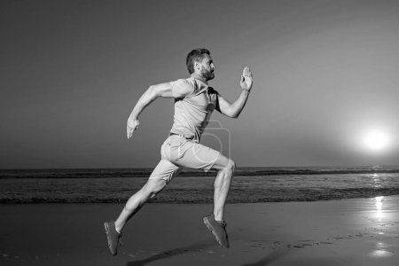 Photo for Man running on the beach at sunset. Guy runner jogger running. Dynamic jumping movement. Sport jump - Royalty Free Image