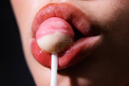 Photo for Close up lips sucking a lolipop, lollypop. Woman with lollipop in mouth. Red lips, sweats lolly pop - Royalty Free Image