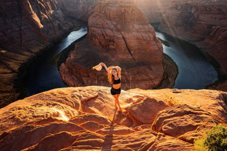 Foto de Famoso lugar de senderismo. Grand canyon, Glen Canyon, Arizona. Concepto de viaje y aventura. Mujer joven mirando a Horseshoe Bend y el río Colorado. Mujer se para sobre el borde de la curva de herradura - Imagen libre de derechos