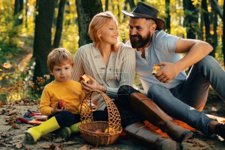 Photo for Autumn family rules respect and thankfulness for positive behaviour. Young father and mother playing with their cute and little son. The season outside with fall activities, searching for fall colors - Royalty Free Image