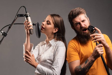 Foto de Pareja de cantantes de karaoke. Mujer y hombre cantando con micrófono de música - Imagen libre de derechos