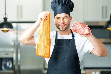 Photo for Portrait of attractive man preparing fresh natural meal at kitchen home indoors. Handsome cheerful man preparing raw fish and meat, salmon and beef. Healthy food, cooking concept - Royalty Free Image