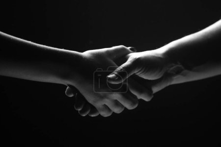 Photo for Hands gesturing on black background. Giving a helping hand. Support and help, agreement. Hands of two people of rescue. Helping hand outstretched for salvation. Handshake between the two partners - Royalty Free Image