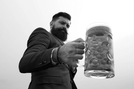 Foto de El hombre toma un vaso de cerveza, enfoque selectivo. Tazas de cerveza - Imagen libre de derechos