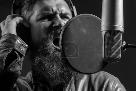 Téléchargez les photos : Concept de microphone. Producteur sonore enregistrant une chanson dans un studio de musique. Karaoké excité - en image libre de droit