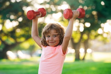 Photo for Kids sporty lifestyle. Boy workout in park. Kid sport. Child exercising with dumbbells. Sporty child with dumbbell outdoor - Royalty Free Image