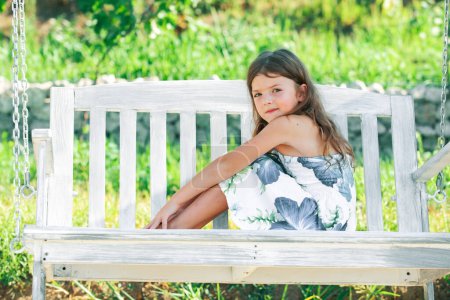 Photo for Cute little girl on a swing. Smiling child playing outdoors in summer. Happy mother swinging daughter at the park. Child chill and resting in summer holiday - Royalty Free Image