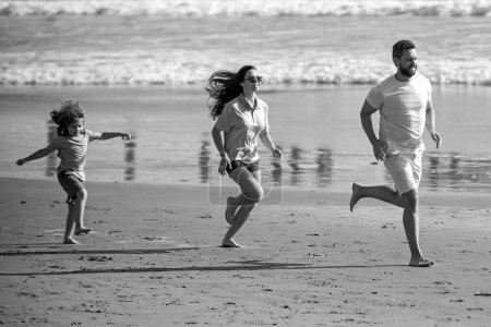 Foto de Familia de fitness corriendo en la playa. Madre feliz padre con hijo hijo, divertirse durante las vacaciones de verano. Familia corriendo al aire libre con el niño. Deporte, salud en verano. Estilo de vida saludable - Imagen libre de derechos