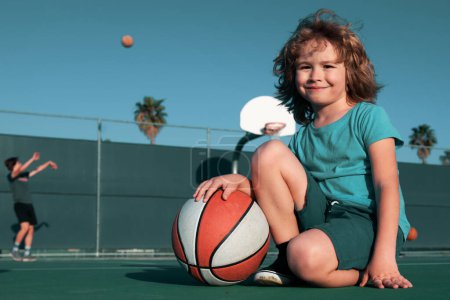 Foto de Estilo de vida saludable para niños. Niño jugando al baloncesto. Actividad deportiva infantil. Sonriente chico juega pelota - Imagen libre de derechos