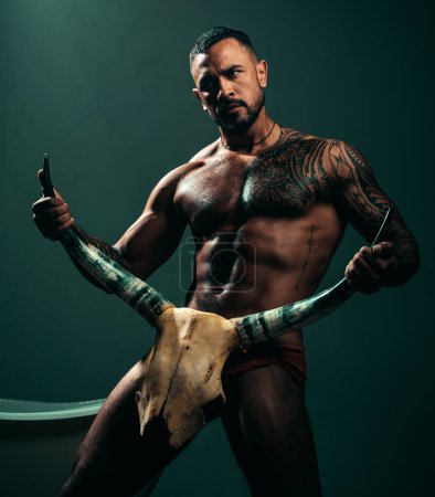 Photo for Improving male sexual performance. Sexy hispanic macho with muscular body and sexual nature holding animals skull and horns. Sexi latino man showing his sexual desire and attraction. - Royalty Free Image