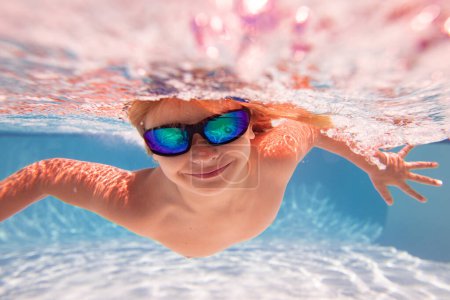 Téléchargez les photos : Il nage sous l'eau. Les enfants d'été. Joyeux petit garçon dans la piscine le jour de l'été. Enfant drôle nageant et plongeant dans la piscine. Enfant sous l'eau avec éclaboussures. Sports nautiques pour enfants d'été - en image libre de droit