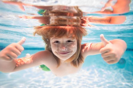 Téléchargez les photos : Enfant dans la piscine le jour d'été. Enfant nageant sous l'eau dans la piscine. Des gosses drôles. Les enfants nagent dans l'eau de mer - en image libre de droit