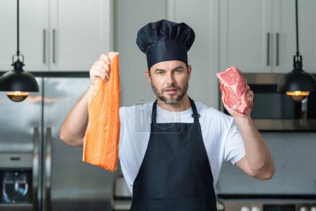 Photo for Man in modern kitchen, preparing healthy food alone, cooking fish and meat, salmon and beef. Handsome man is preparing fresh fish and meat, salmon and beef in the kitchen at home - Royalty Free Image