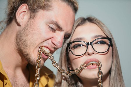 Foto de Couple with chains in mouth closeup. Youth, love and lifestyle concept. Couple of sexy man and sensual woman - Imagen libre de derechos