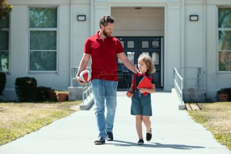 Photo for Outdoor school. School boy going to school with father. Happy Dad and son go to elementary school - Royalty Free Image