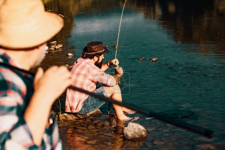 Photo for Leisure and people concept male friends fishing. Summer vacation. Catch me if you can. Fly fish hobby of men. Summer leisure. Master baiter. Weekend. Successful fly fishing - Royalty Free Image