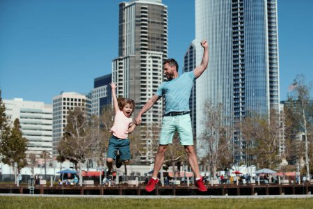 Foto de Padre e hijo saltando en la ciudad. Papá y el niño en la calle American City - Imagen libre de derechos