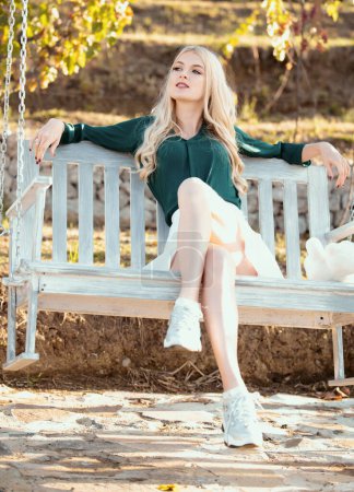 Foto de Sensual mujer balanceándose en el columpio en la naturaleza de verano, joven chica sexy relajarse en el parque de primavera al aire libre - Imagen libre de derechos