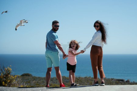 Foto de Vista trasera de la familia despreocupada en las vacaciones en la playa. Familia de estilo de vida - Imagen libre de derechos