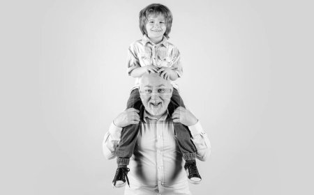 Photo for Old grandfather and young child grandson piggyback with funny face isolated on blue in studio. Granddad and cute boy with funny face - Royalty Free Image