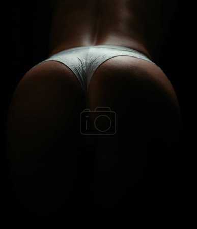 Téléchargez les photos : Female back and buttocks close up. Woman posing in sexy lace underwear on beautiful ass buttocks. Erotic lingerie. Beauty model ass in a bikini on butt - en image libre de droit
