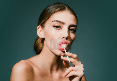 Photo for Woman in studio lick lollipop, isolated headshot portrait. Portrait seductive woman with bare shoulders - Royalty Free Image