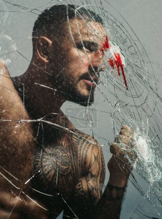 Photo for Handsome brutal man near broken glass. Brutal handsome macho focused on fight result. Want to fight right now. Fight concept. Man muscular body punching. Concentrated on target. Destroy obstacles. - Royalty Free Image